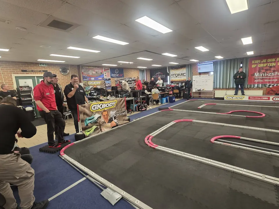 Rijders en bezoekers bij het Mini-Z-circuit met de werktafels op de achtergrond