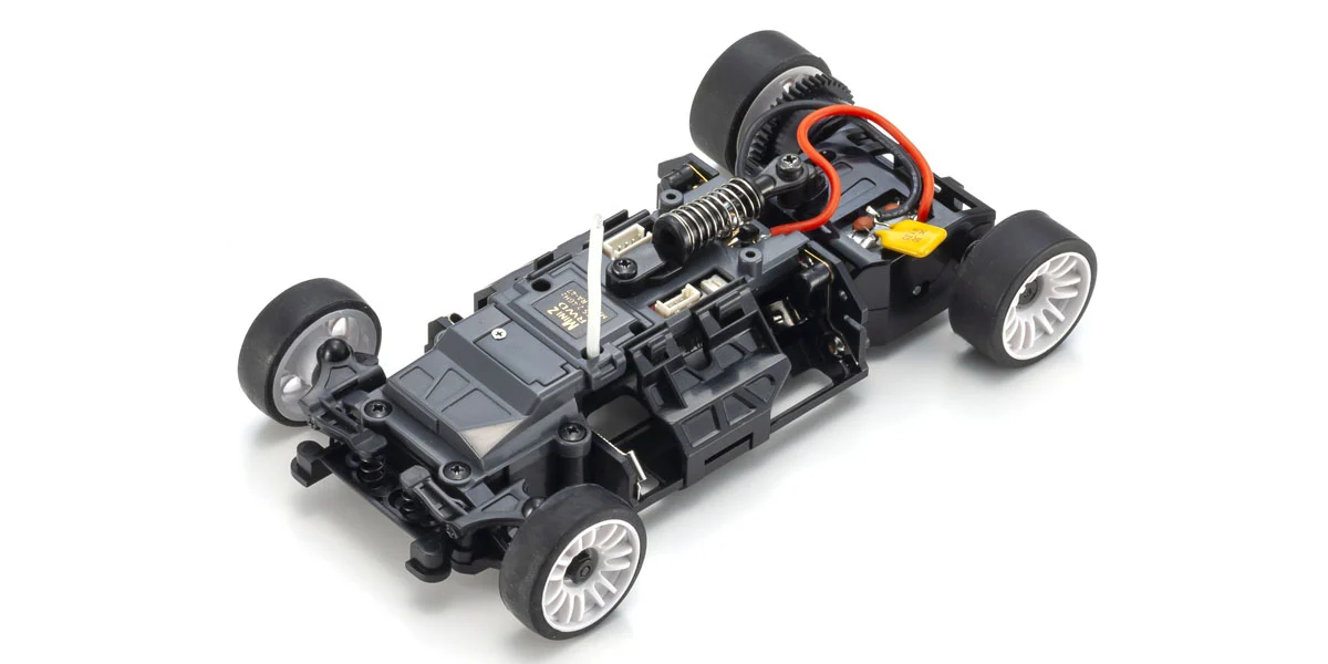 Officiële foto van een Kyosho MR-04 RWD chassis zonder carrosserie, met voorophanging, batterijhouders en achterste motorpod