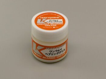 Een klein wit potje met een oranje etiket. Op het etiket staat 'TEAM KYOSHO ONEWAY BEARING GREASE' en Japanse tekst.
