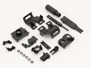 De afbeelding toont een verzameling zwarte plastic onderdelen voor een RC-auto chassis. De onderdelen variëren in vorm en grootte, en lijken ontworpen te zijn voor montage en reparatie.