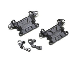 De afbeelding toont vier zwarte, kunststof onderdelen. Twee grotere, rechthoekige onderdelen met uitstekende bevestigingspunten en het woord 'KYOSHO' erop, en twee kleinere, onregelmatig gevormde onderdelen met gaten.