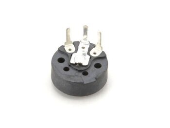 De foto toont een klein, rond, zwart elektronisch component met drie zilverkleurige metalen pinnen aan de bovenzijde. Het lijkt op een potentiometer.