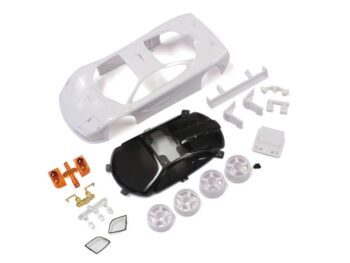De afbeelding toont een bouwpakket van een modelauto, bestaande uit een witte carrosserie, een zwart chassis, vier witte velgen en diverse kleine onderdelen in wit, oranje en transparant plastic.