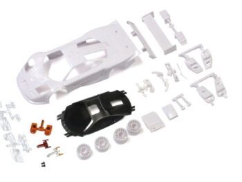 De afbeelding toont een bouwpakket van een modelauto, bestaande uit diverse onderdelen in verschillende kleuren, voornamelijk wit en zwart. Het omvat de carrosserie, wielen en andere kleine onderdelen die nodig zijn voor de assemblage.