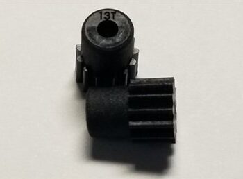 Op de foto zijn twee zwarte tandwielen te zien, gemaakt van een mat plastic-achtig materiaal. Eén tandwiel staat rechtop en heeft '13T' erop gegraveerd, het andere ligt ernaast.