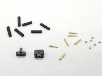 De afbeelding toont een set van zwarte plastic connectoren en gouden metalen pinnen, samen met enkele kleine zilverkleurige onderdelen. Er zijn twee grotere zwarte connectorbehuizingen zichtbaar, waarvan één met een 'GL' logo.