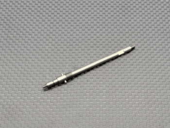 De afbeelding toont een lange, dunne, zilverkleurige metalen as met aan één uiteinde schroefdraad en aan het andere uiteinde een platte kant. Halverwege de as zit een verdikking met een veer en twee kleine uitsteeksels.