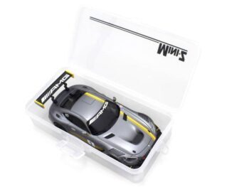 De afbeelding toont een doorzichtige opbergdoos met een zilverkleurige modelauto met gele accenten erin. De doos heeft een deksel met een logo.