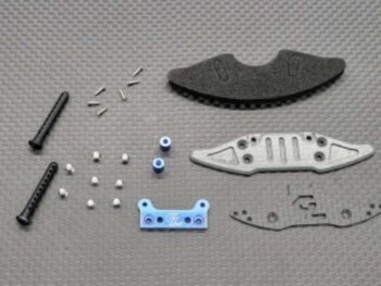 De afbeelding toont diverse onderdelen voor een RC-auto, waaronder een blauw geanodiseerd aluminium onderdeel met het 'GL' logo, een grijs metalen plaat, een zwart schuimrubberen onderdeel, twee zwarte plastic pinnen en diverse kleine zilverkleurige schroefjes en busjes.