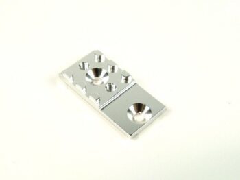 De foto toont een zilverkleurig, rechthoekig metalen onderdeel met diverse verzonken gaten en verhoogde randen. Het lijkt een precisie-onderdeel te zijn, mogelijk voor montage.