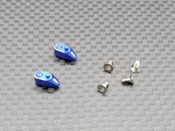 Op de foto zijn twee blauwe, metalen onderdelen te zien met een afgeronde, druppelachtige vorm en schroefgaten. Daarnaast liggen vier zilverkleurige schroeven met een platte kop en inbusaansluiting.