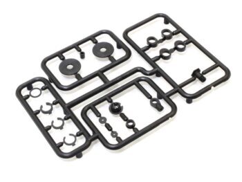 De afbeelding toont een set zwarte plastic onderdelen op een wit oppervlak. De onderdelen zijn bevestigd aan een spruw, wat duidt op modelbouw of reserveonderdelen.