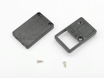 De foto toont een tweedelige, rechthoekige zwarte plastic behuizing voor een ontvanger, samen met twee kleine schroefjes. Op een van de delen is tekst te zien, waaronder 'CH1', 'CH2', 'CH3', 'CH4' en 'Bind'.