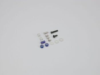 De afbeelding toont een set kleine onderdelen, waaronder zilverkleurige veren, schroeven in zilver en zwart, blauwe moeren en ringen. De onderdelen zijn van metaal en kunststof en liggen verspreid op een lichtgrijze achtergrond.
