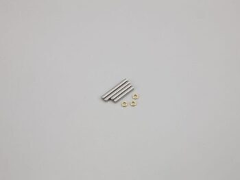 De foto toont drie zilverkleurige, cilindervormige pinnen en drie kleine goudkleurige ringetjes op een grijze achtergrond.