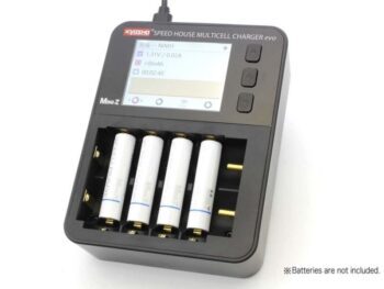 Een zwarte, rechthoekige acculader met een LCD-scherm en vier sleuven voor batterijen. Op het scherm is informatie over het laadproces te zien en er staat 'Kyosho Speed House Multicell Charger Evo Mini-Z' op de behuizing.