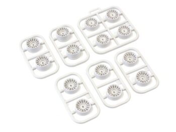 De foto toont meerdere sets witte plastic velgen, elk in een frame van hetzelfde materiaal. De velgen hebben een multi-spaaks design.