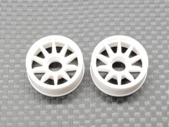De afbeelding toont twee witte, plastic velgen met een multi-spaaks design. Ze liggen naast elkaar op een donkere, geruite ondergrond.