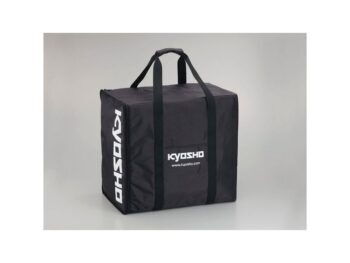 De foto toont een zwarte, rechthoekige draagtas met twee handvatten aan de bovenkant. Op de zijkant en voorkant staat het witte 'KYOSHO' logo en de website 'www.kyosho.com'.