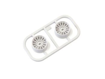 De afbeelding toont twee witte kunststof velgen, nog bevestigd aan een gietframe. De velgen hebben een multi-spaaks design.