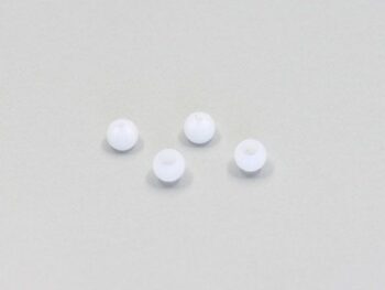 De afbeelding toont vier kleine, ronde, witte busjes met een gat in het midden, liggend op een lichtgrijze ondergrond.