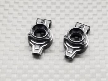 Twee zilverkleurige metalen onderdelen met een complexe, ronde vorm en uitstekende bevestigingspunten, liggend op een witte ondergrond met een subtiel ruitpatroon.
