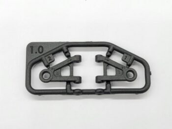 Op de foto is een zwart plastic onderdeel te zien, bestaande uit twee identieke armen die nog aan een gietraam vastzitten. Er staat '1.0' en '1' en '2' op het gietraam en de onderdelen.