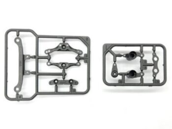 De afbeelding toont twee grijze plastic onderdelenframes met diverse kleine onderdelen voor een RC auto. De onderdelen zijn onuitgepakt en nog aan het frame bevestigd.