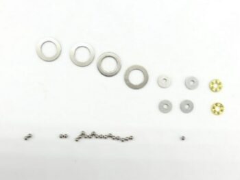 De afbeelding toont een set van verschillende metalen ringen en kleine metalen balletjes op een witte achtergrond. De ringen variëren in grootte en zijn voornamelijk zilverkleurig, met twee kleinere ringen die goudkleurig zijn.
