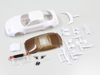 The image shows a white, unpainted body of an RC car, along with a transparent brown window set and various small white and black parts, including mirrors and a rear spoiler. These are all parts for a model car.