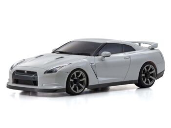 Op de foto is een gedetailleerde, witte modelauto te zien, een Nissan Skyline GT-R R35, met donkere ramen en velgen. Het is een carrosserie van een RC-auto, zonder chassis.
