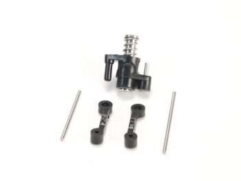 De afbeelding toont een zwarte servo saver set met een metalen veer en twee plastic verbindingsstukken, gemarkeerd met 'K' en 'P'. Er liggen ook twee metalen pinnen naast de onderdelen.