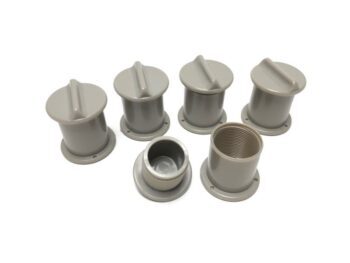 De foto toont een aantal grijze, cilindervormige plastic onderdelen met een ronde basis en een handvat op de bovenkant. Eén onderdeel heeft schroefdraad aan de binnenkant.