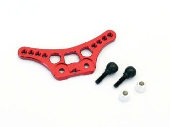 De afbeelding toont een rood geanodiseerd aluminium onderdeel met diverse gaten en uitsparingen, waarschijnlijk een schokdemperbevestiging. Daarnaast liggen twee zwarte schroeven met kogelkoppen en twee kleine zilverkleurige busjes.