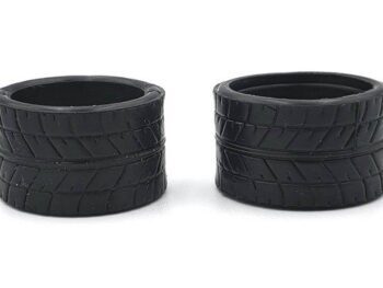 De afbeelding toont twee zwarte rubberen banden voor RC-auto's. De banden hebben een duidelijk profiel met diagonale lijnen.