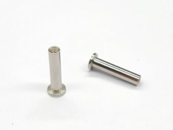 De foto toont twee zilverkleurige, metalen staafjes met een platte kop aan één uiteinde. Eén staafje heeft interne schroefdraad aan het open uiteinde, terwijl het andere staafje glad is aan het open uiteinde.