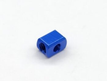 Op de foto is een klein, blauw, rechthoekig metalen onderdeel te zien met twee ronde openingen, waarvan één met schroefdraad. Het oppervlak is glanzend en reflecterend.