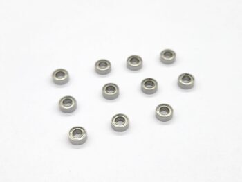 De foto toont een verzameling van elf kleine, zilverkleurige kogellagers verspreid over een witte achtergrond. Ze zijn rond van vorm en hebben een glanzende, metalen afwerking.