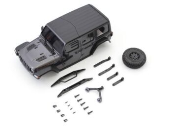 De afbeelding toont een gedemonteerde carrosserie van een Jeep Wrangler Rubicon in een donkergrijze kleur, samen met diverse zwarte onderdelen zoals bumpers, een reservewiel en schroeven. Het geheel ligt op een witte achtergrond.