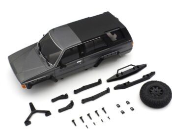 De foto toont een grijze modelauto carrosserie van een Toyota 4Runner, samen met diverse zwarte onderdelen zoals bumpers, spatborden, een reservewiel en schroeven. Het geheel ligt op een witte achtergrond.