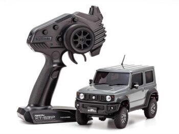 De foto toont een grijze, gedetailleerde RC-auto, een Suzuki Jimny Sierra, naast een zwarte afstandsbediening. De auto heeft robuuste banden en een realistische uitstraling.