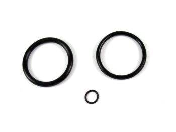 Op de foto zijn drie zwarte O-ringen te zien, twee grote en één kleine, liggend op een witte achtergrond. Ze zijn rond en lijken van rubber of een vergelijkbaar elastisch materiaal te zijn gemaakt.