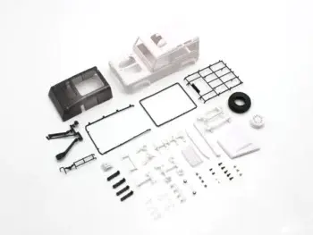 De afbeelding toont een bouwpakket voor een modelauto, voornamelijk bestaande uit witte en zwarte plastic onderdelen. Het betreft een carrosserie van een Land Rover Defender, samen met diverse kleine onderdelen zoals een dakrek, band en schroeven.