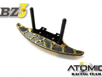 De foto toont een gouden bumper met zwarte details en twee zwarte bodyposts. De bumper heeft een gebogen vorm en is gemaakt van een combinatie van materialen.