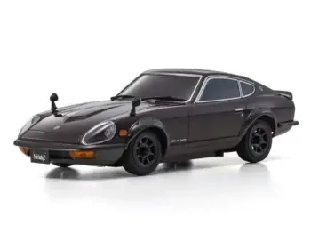 De afbeelding toont een gedetailleerde modelauto, een Nissan Fairlady 240 ZG, in een donkerrode (maroon) kleur met zwarte accenten en zilverkleurige raamomlijsting. Het is een klassieke sportwagen met een lange motorkap en een fastback-ontwerp.