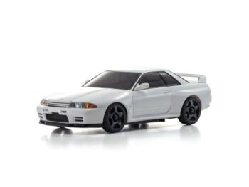 De foto toont een witte modelauto, een Nissan Skyline GT-R R32, met zwarte velgen en getinte ramen. Het is een gedetailleerde replica van de sportwagen.