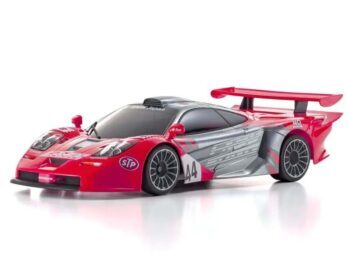 De afbeelding toont een rode en zilverkleurige raceauto body met een grote achterspoiler en diverse sponsorlogo's. Het is een gedetailleerde miniatuurversie van een McLaren F1 GTR.