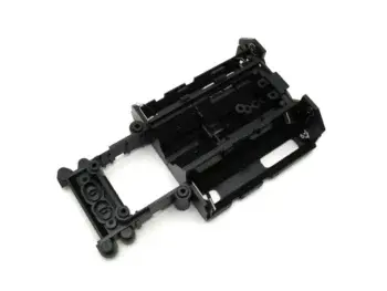 De afbeelding toont een zwart, kunststof hoofdchassis voor een RC-auto. Het chassis heeft diverse uitsparingen en bevestigingspunten voor elektronica en onderdelen.