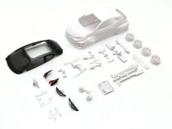 La imagen muestra un kit de montaje para un modelo de coche, compuesto por una carrocería blanca de un Toyota Yaris GRMN, una parte inferior negra y varias piezas pequeñas blancas y transparentes, como ruedas y componentes del chasis.