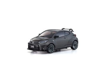 En la foto se puede ver una maqueta detallada de un Toyota GRMN Yaris en color gris oscuro mate. La maqueta tiene un aspecto deportivo, con un alerón trasero y llantas detalladas.